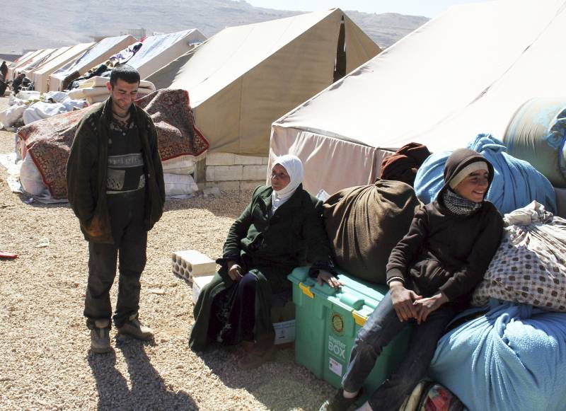 Varios refugiados sirios que abandonaron las localidades de Flita y Yabroud debido a la violencia esperan una tienda de campaña en el campo de refugiados de Arsal, Líbano. / Efe