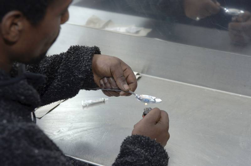 Un heroinómano prepara una dosis intravenosa. / EFE