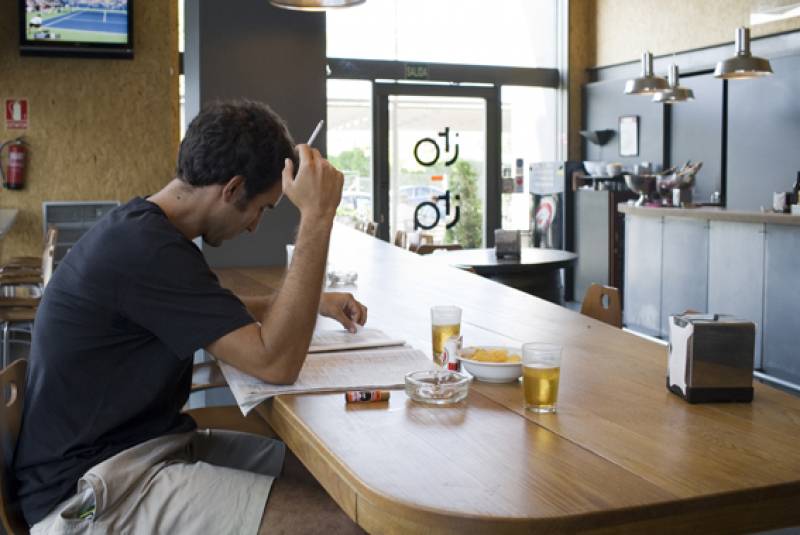 Un joven fuma en un bar