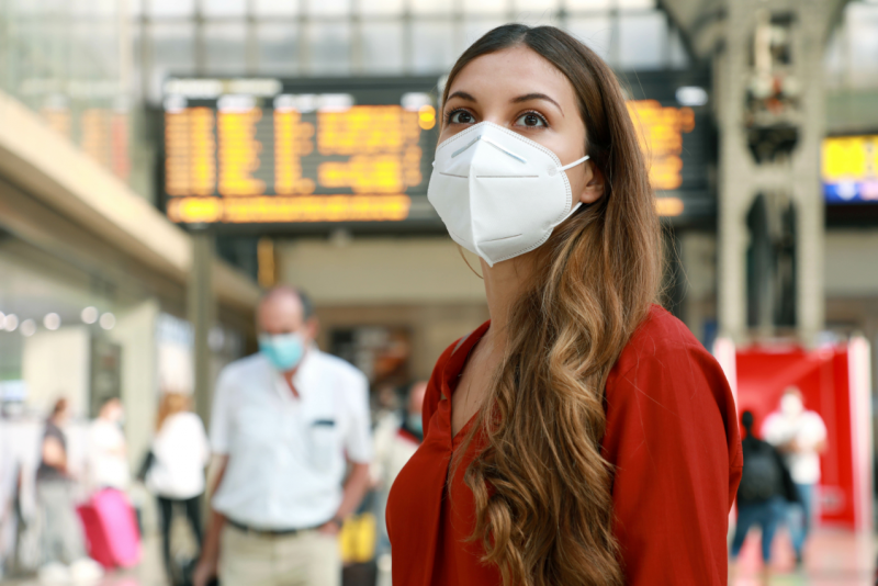 mujer con mascarilla en una estación