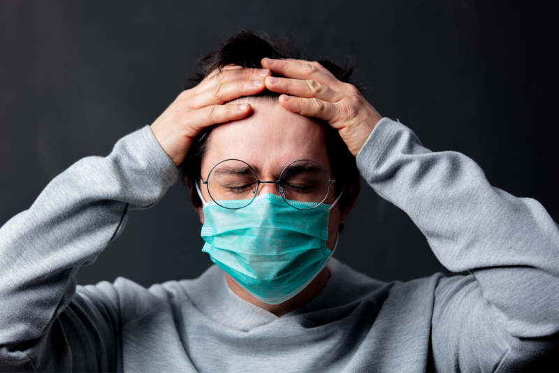 hombre con gafas y mascarilla se agarra la cabeza