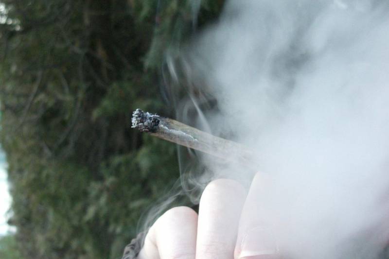 Una persona consume un porro de cannabis