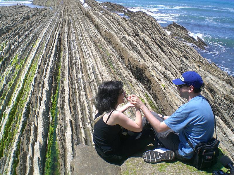 Salva aprecia el flysch de Zumaia con la ayuda de Almudena, su guía-intérprete. / LCH.