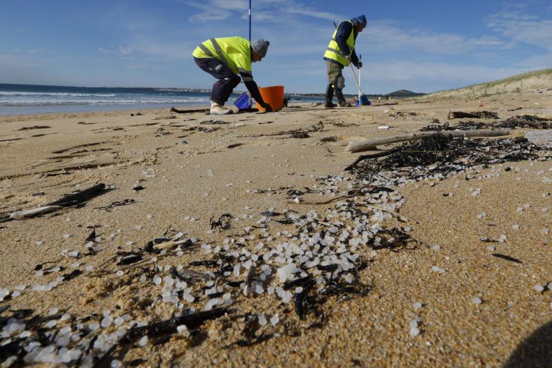 Operarios retiran pellets de plástico