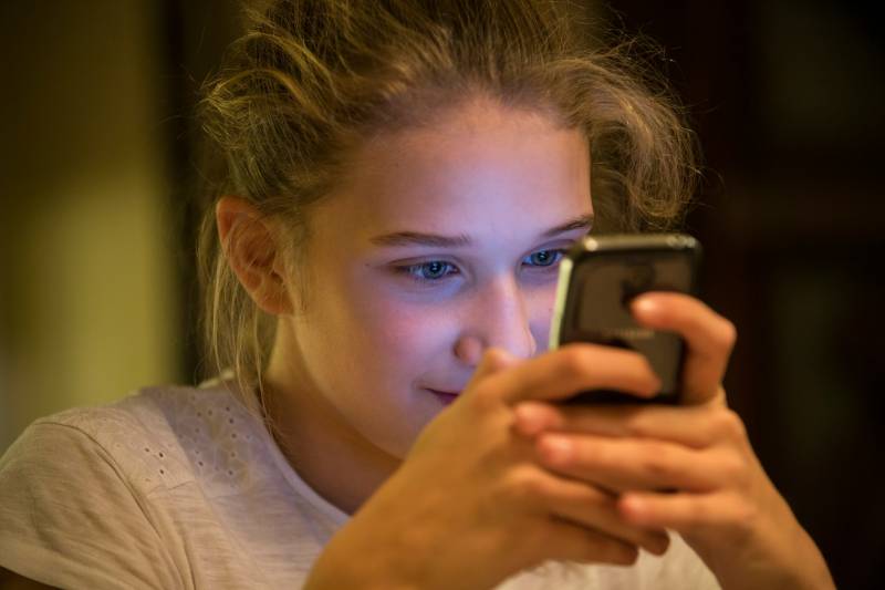 niña con un móvil