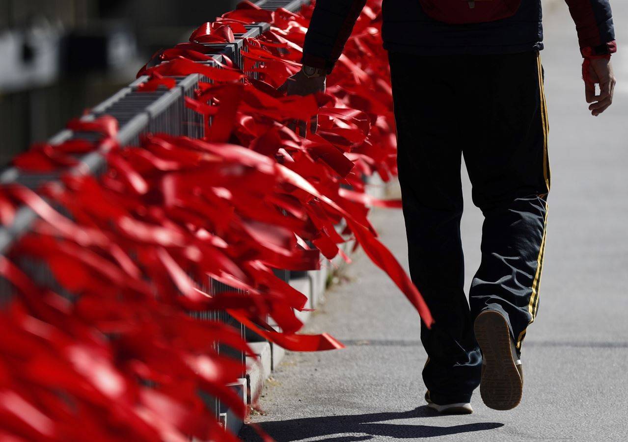 Lazos rojos anudados en una barandilla como conmemoración del Día Mundial de la Lucha contra el Sida. EFE / Javier Lizón