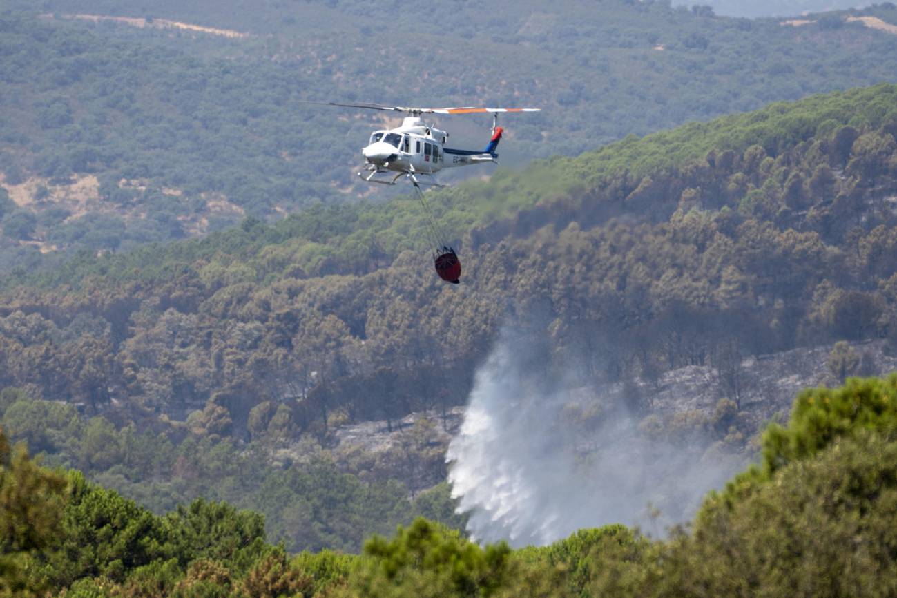 Un helicóptero trabaja en la extinción del incendio producido en el parque natural de Despeñaperros (Jaén). / EFE/José Manuel Pedrosa