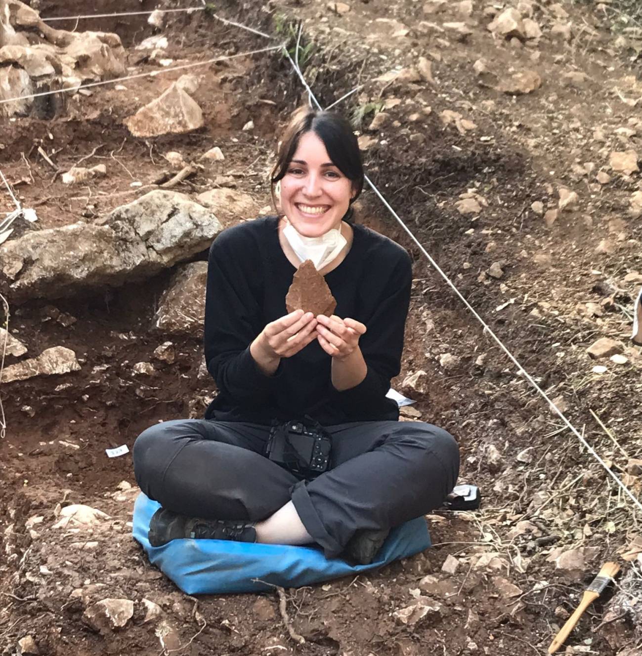 Ana Álvarez Ferández con el bifaz de cuarcita encontrado este año en el yacimiento. / Laura Rodríguez