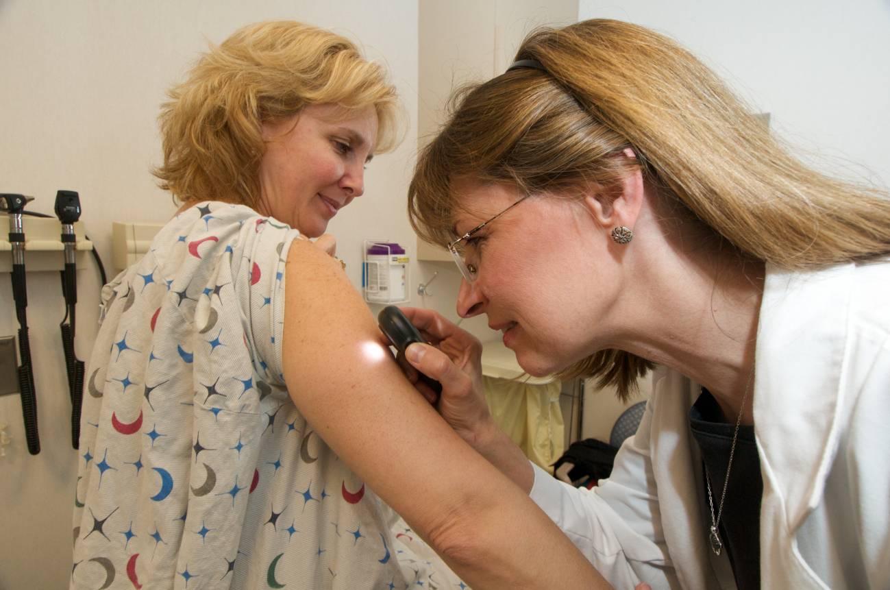 Un médico examina los lunares a una paciente. Imagen por Chistriana Care