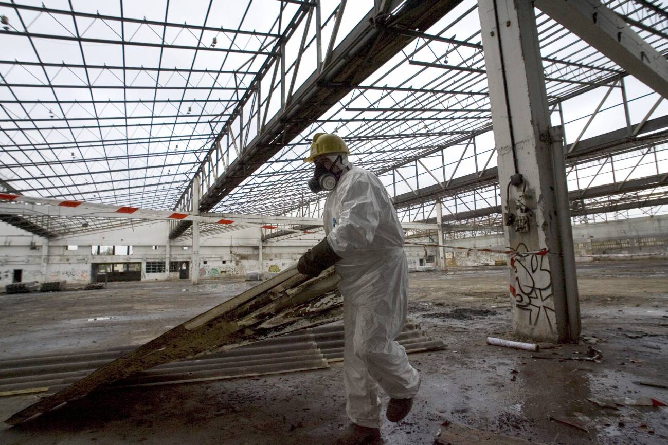 Un operario retira ruinas industriales contaminadas de amianto en el País Vasco. / Efe