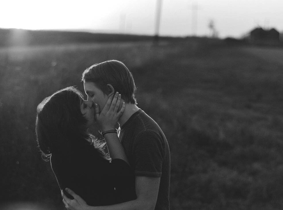 Pareja de jóvenes se besa apasionadamente.