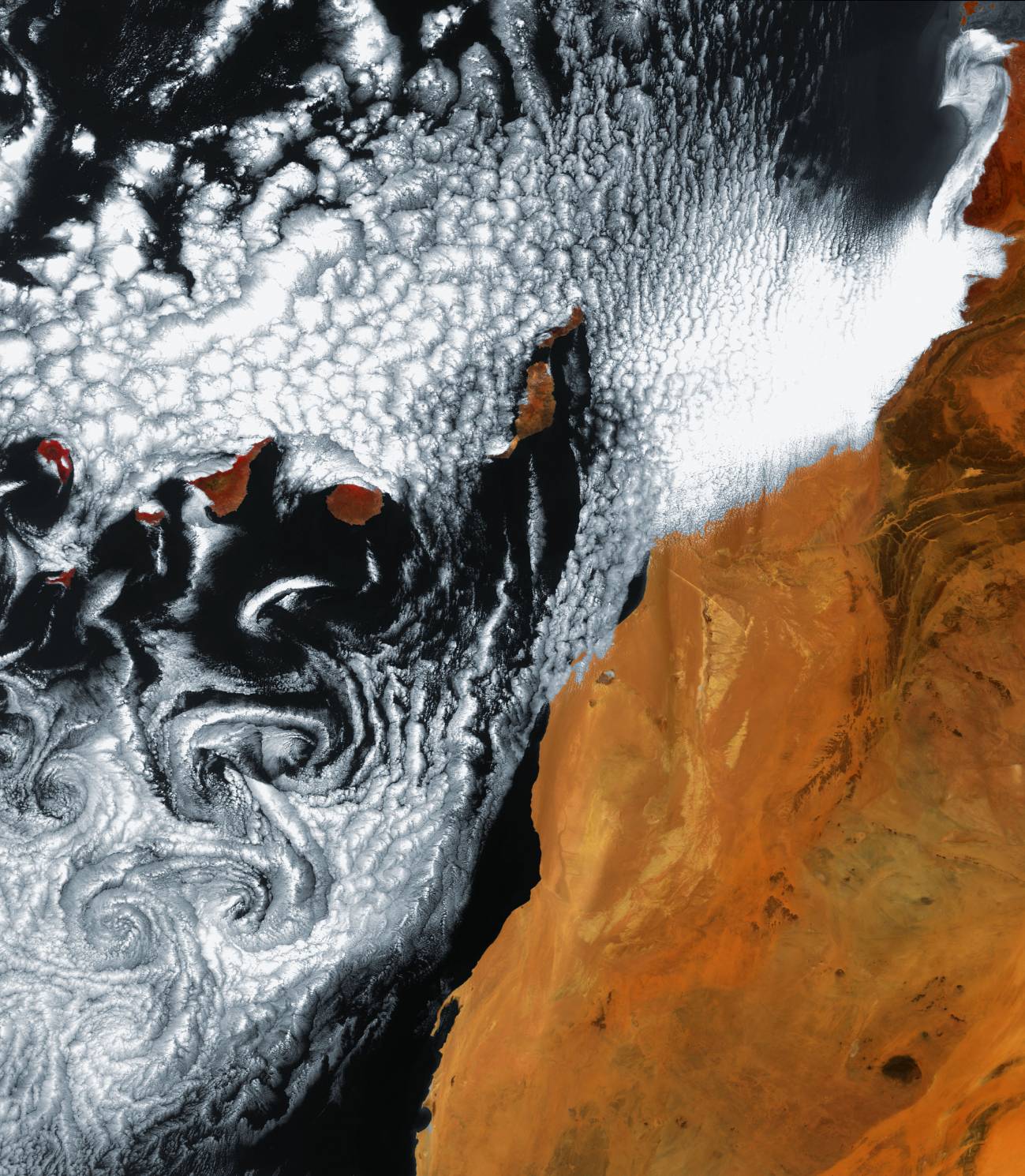 Se observan artísticos remolinos de nubes cerca de Canarias