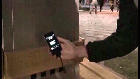 Usuario cargando su dispositivo móvil en un 'árbol de fresas'