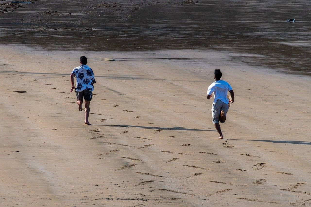 Dos personas corren en la playa
