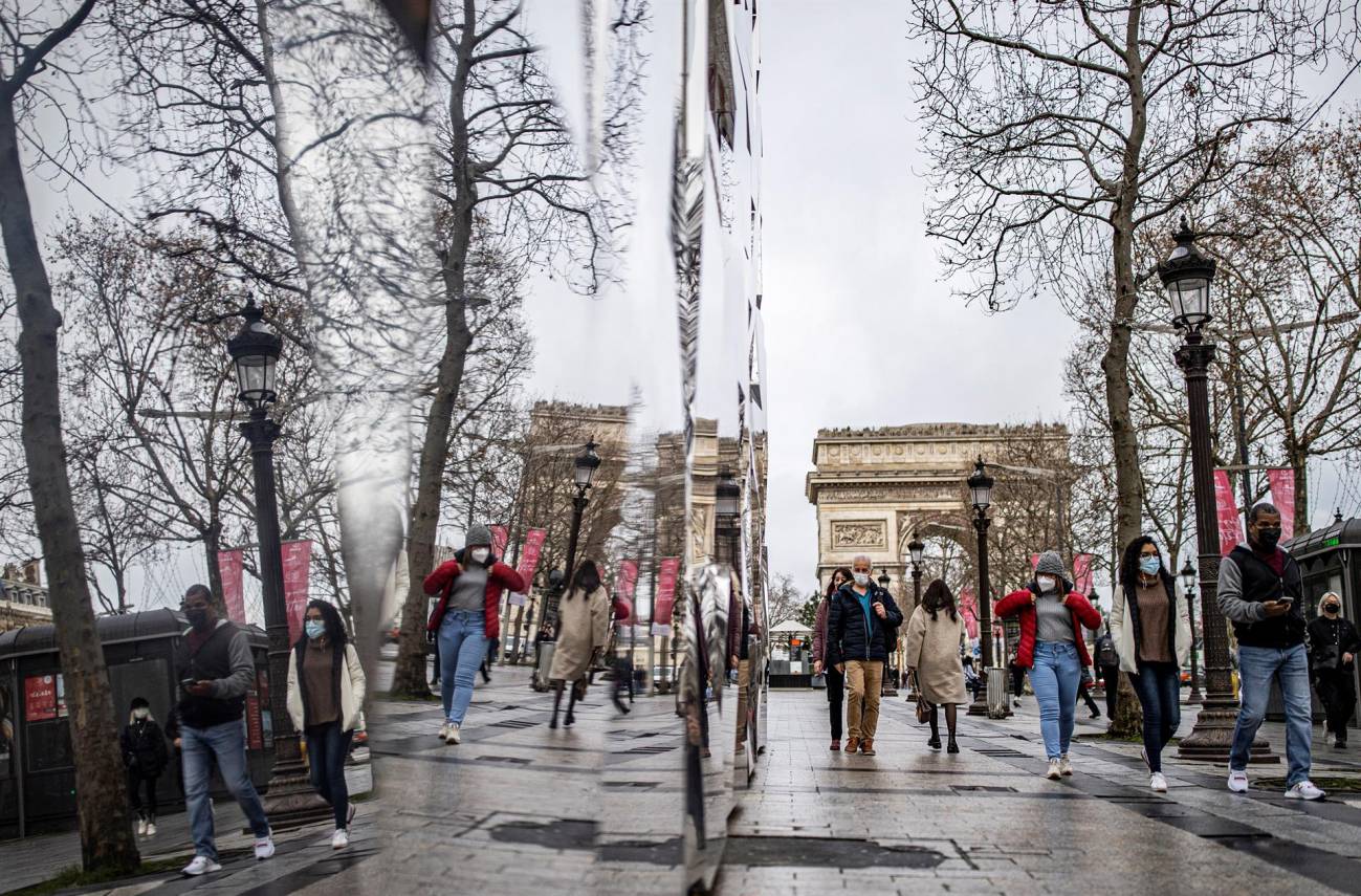 Vista de una calle de Francia en la que se ven personas con mascarillas 