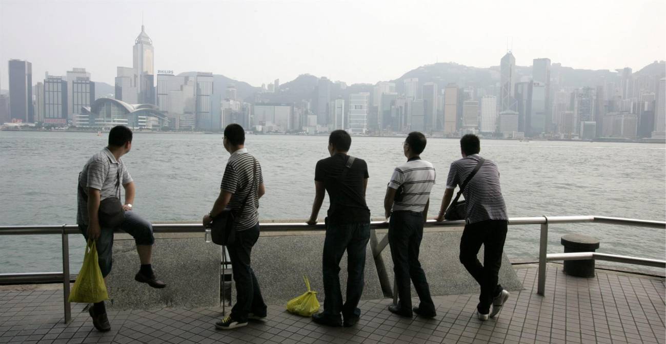 turistas observando el perfil de la ciudad de Hong Kong