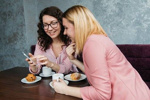 dos chicas hablando en un bar