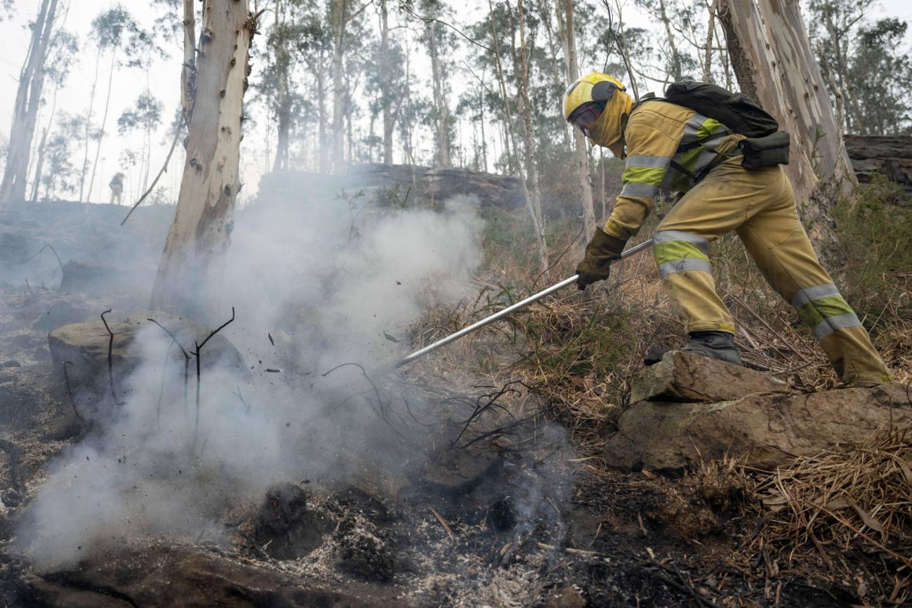 Agentes del Medio Natural y Bomberos Forestales del Gobierno de Cantabria, trabajan, este viernes, en la extinción de un incendio declarado en los montes próximos a la localidad cántabra de Selaya.