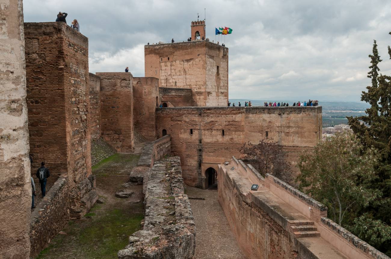 Vista en primer plano de la barbacana y muralla de la Alcazaba, por detrás la torre de armas y al fondo torre de la Vela
