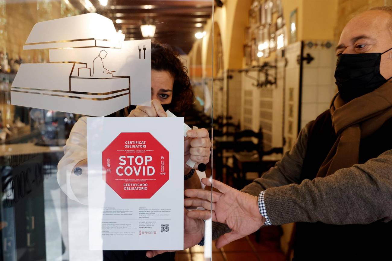 Personal de un hotel coloca un cartel a la entrada de su restaurante avisando de la obligatoriedad del pasaporte covid