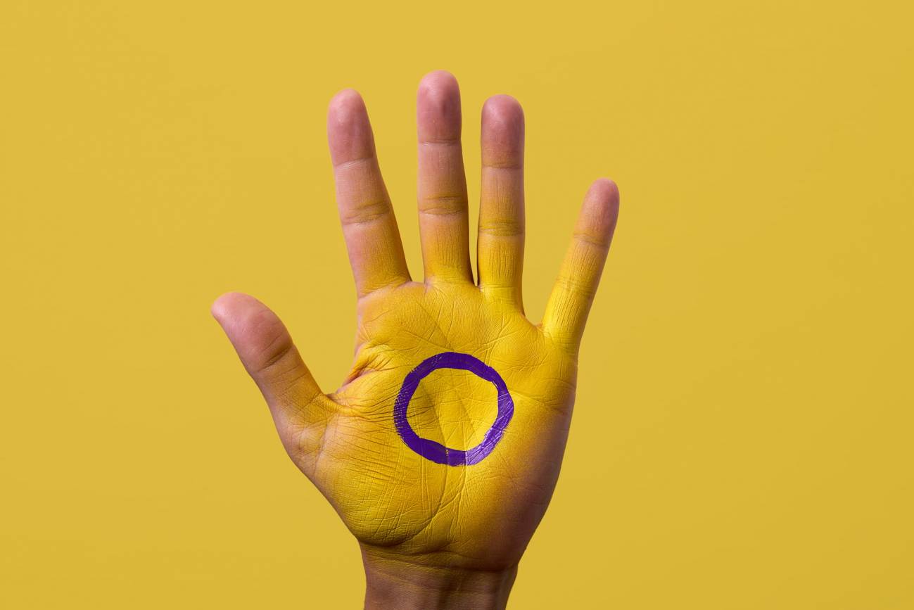 Mano pintada con la bandera intersexual