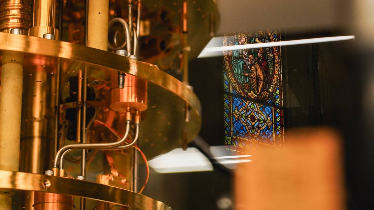 Las estructuras de cobre y oro del computador cuántico se reflejan junto a las vidrieras originales de la capilla neogótica de Torre Girona