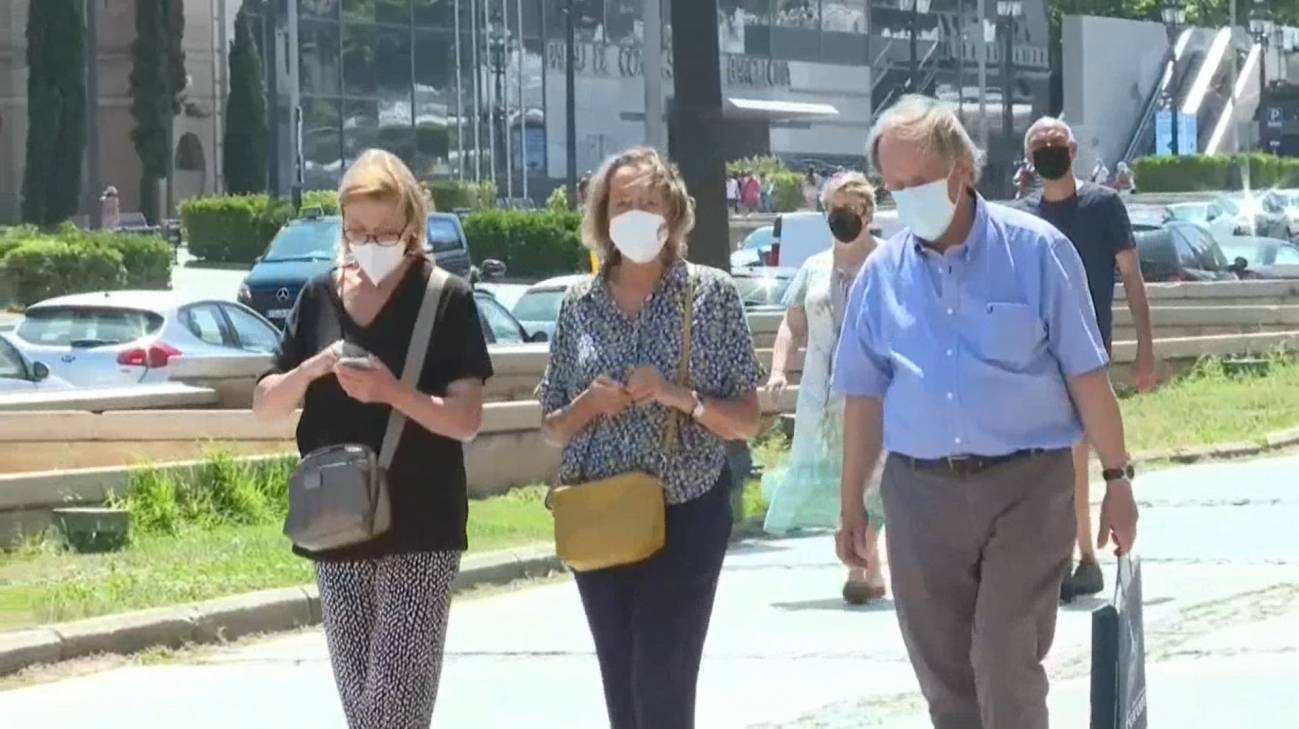 Personas paseando con mascarillas en exterior