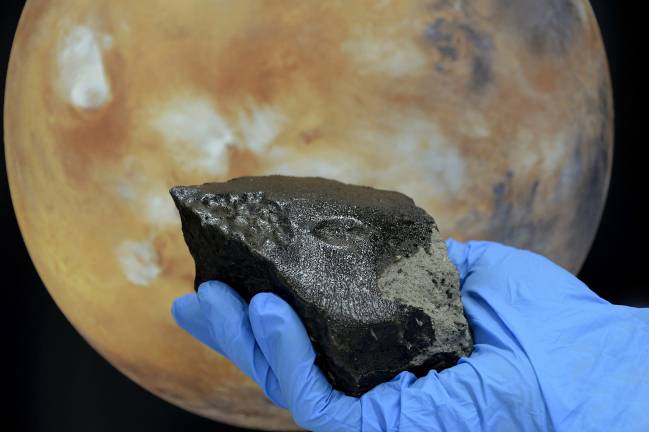  La roca presenta un característico vidrio negro. Imagen: Natural History Museum London