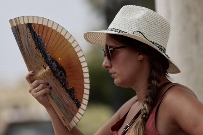 Una joven combate el calor con un abanico