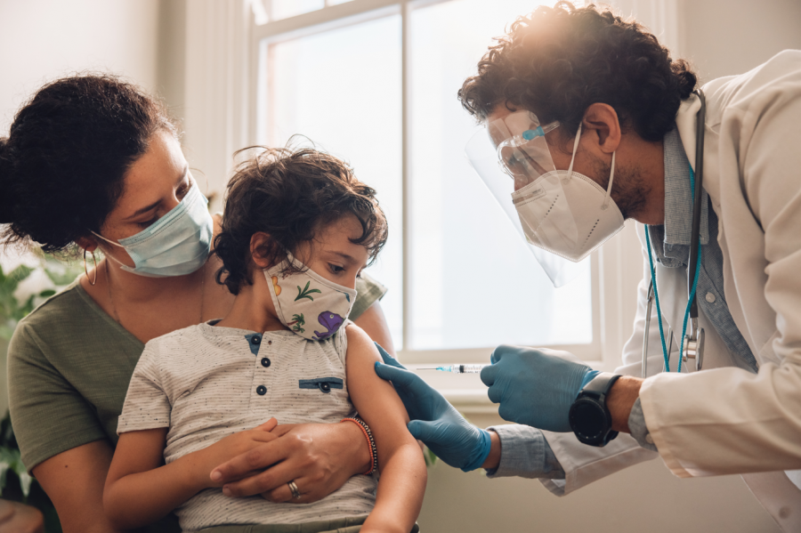 Niño con su madre y un sanitario que va a vacunarle