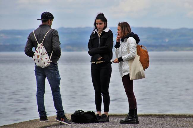 jóvenes fumando a orillas del mar