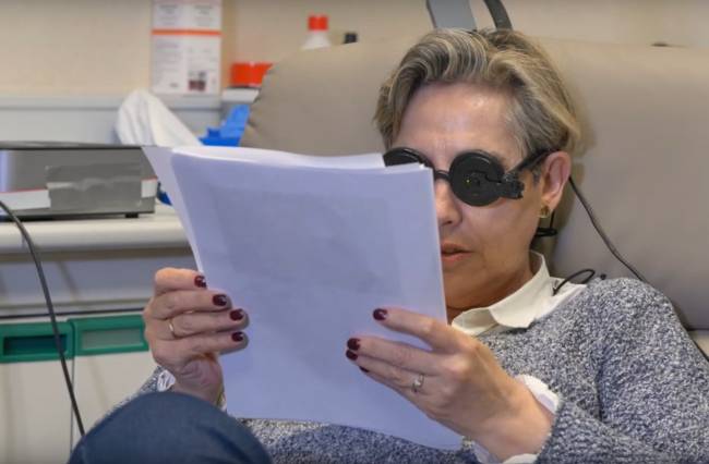 mujer probando el dispositivo capaz de inducir la percepción de formas y letras en una persona ciega