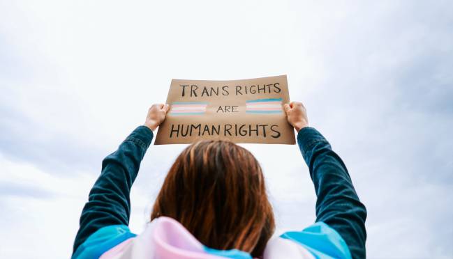 persona con una pancarta a favor de los derechos del colectivo trans