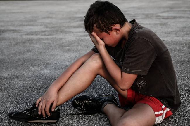 niño con ropa de deporte llorando