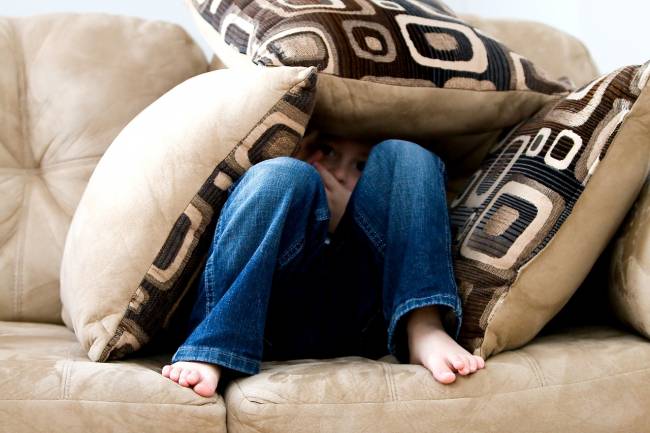 niño en un sofá con pies descalzos