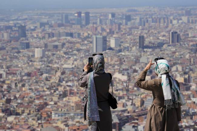 Turistas en el Turó de la Rovira de Barcelona este mes de junio de 2025 en medio de la ola de calor.
