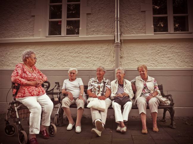 mujeres jubiladas hablando en un banco