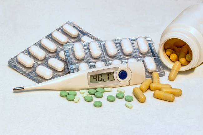 termómetro con 40 grados de fiebre y pastillas