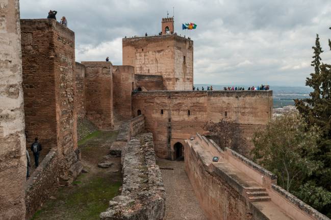 Vista en primer plano de la barbacana y muralla de la Alcazaba, por detrás la torre de armas y al fondo torre de la Vela