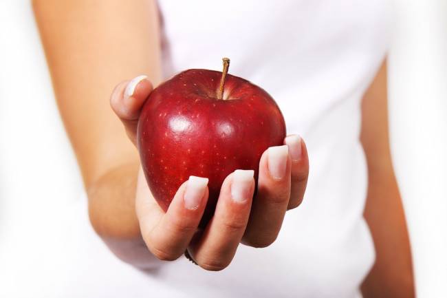 mujer con una manzana en la mano