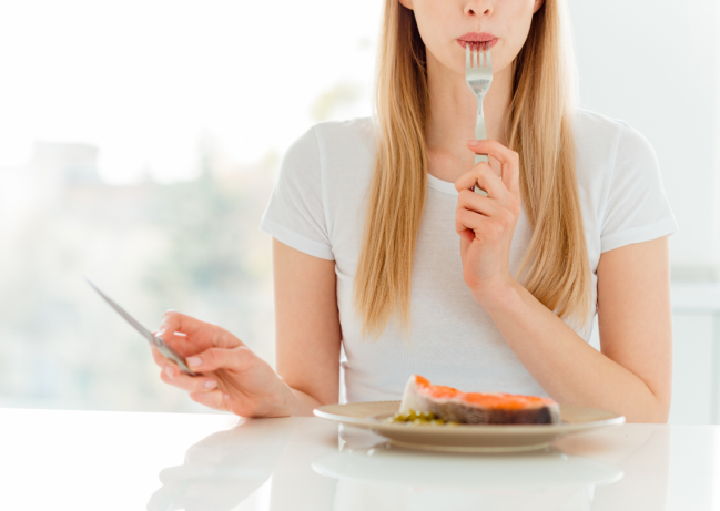 mujer comiendo pescado