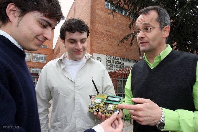 Los dos estudiantes junto al tutor del proyecto muestran el dispositivo de localización de accidentes