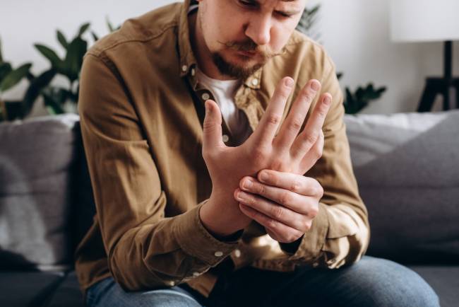 hombre se sujeta la mano