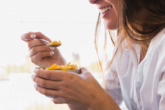 Mujer tomándose unos cereales.