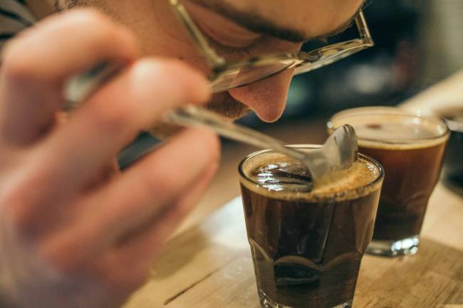 un hombre huele un café