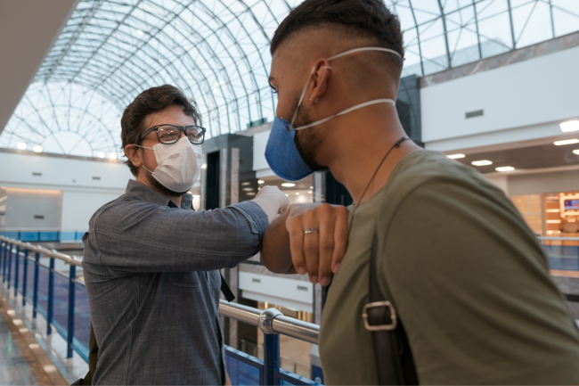 personas saludándose con mascarilla