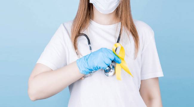 sanitaria con el lazo amarillo del cáncer infantil