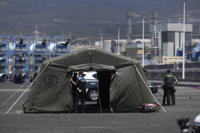 Agentes de la Guardia Civil y de la Policía Portuaria junto al puesto de mando instalado este viernes en el puerto de Granadilla, en Tenerife, con motivo de la llegada del crucero MV Hondius
