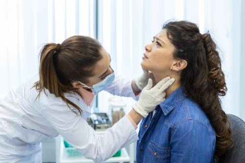 mujer a la que examinan la garganta