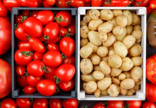 Imagen de una caja de tomates y una caja de patatas